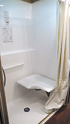 A roll-in shower with a fold-down seat allows wheelchair user, to transfer easily for a sit-down shower.