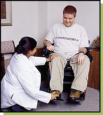 Pandya checks Chad O'Connell's wheelchair for comfort and proper body alignment.